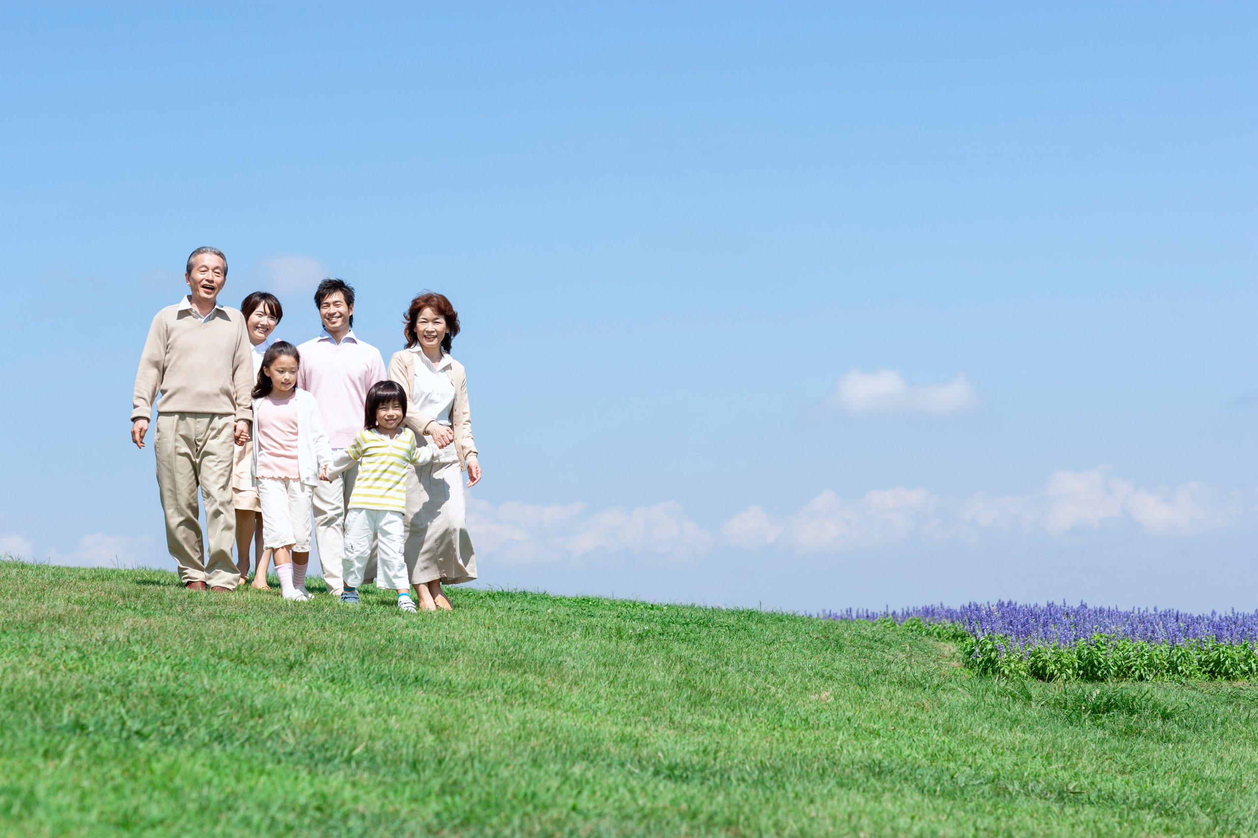 芝生を歩く三世代家族